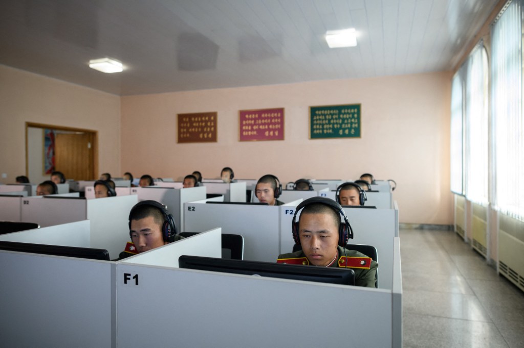 Students wearing Korean People's Army (KPA) uniforms sit before computer screens as they attend a class at the Mangyongdae Revolutionary School outside Pyongyang.