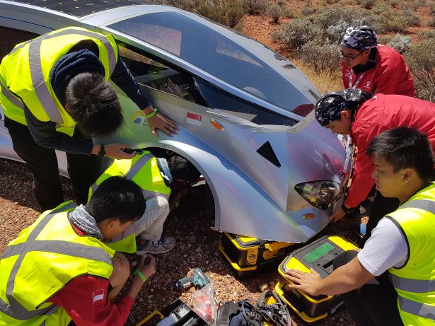 People assembling car